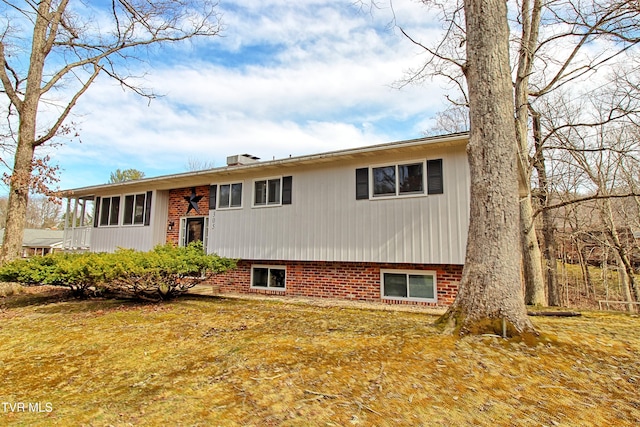 raised ranch with brick siding and a chimney