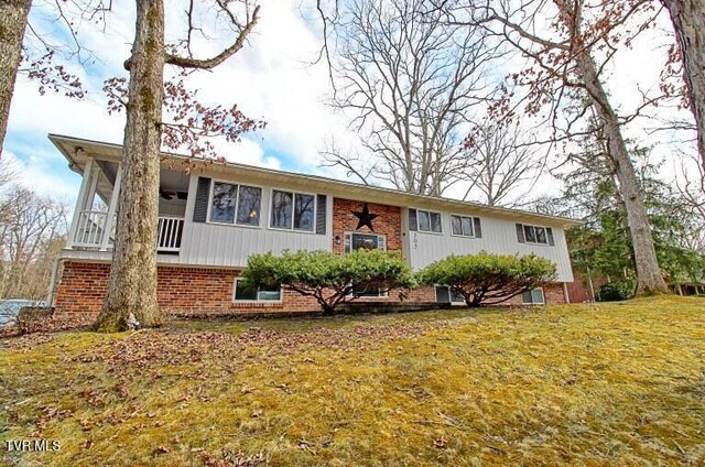 view of front of home featuring a front lawn and brick siding