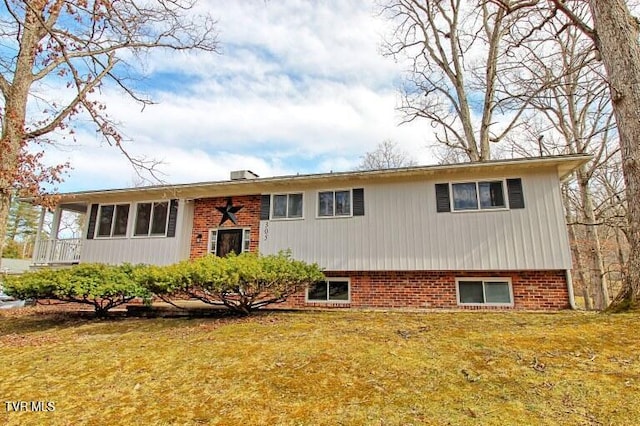 view of front of house with a front yard and brick siding