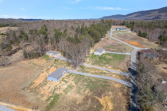 birds eye view of property featuring a rural view, a mountain view, and a wooded view