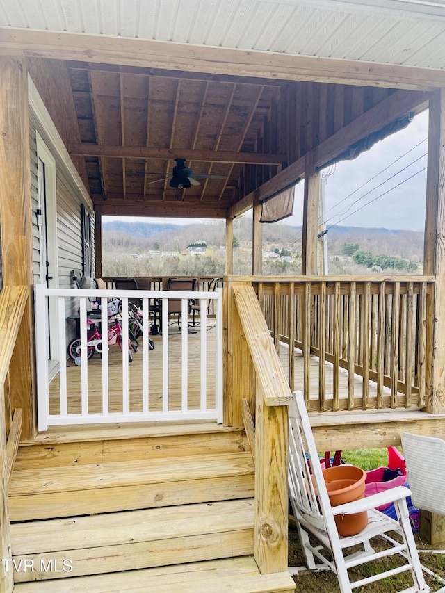 wooden terrace with a mountain view and a ceiling fan