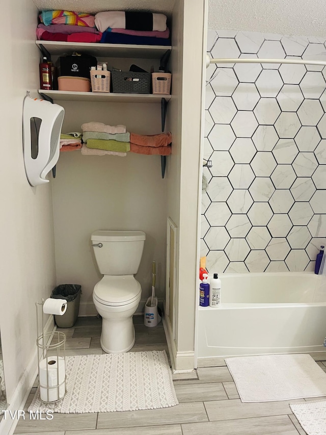 bathroom with wood finished floors, toilet, a bath, and a shower