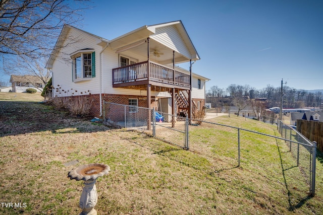 back of house with a lawn, a ceiling fan, a fenced backyard, stairway, and a wooden deck