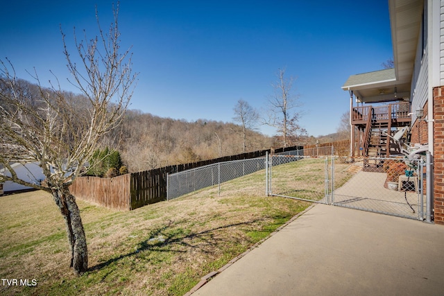 view of yard with a fenced backyard, stairs, and a gate