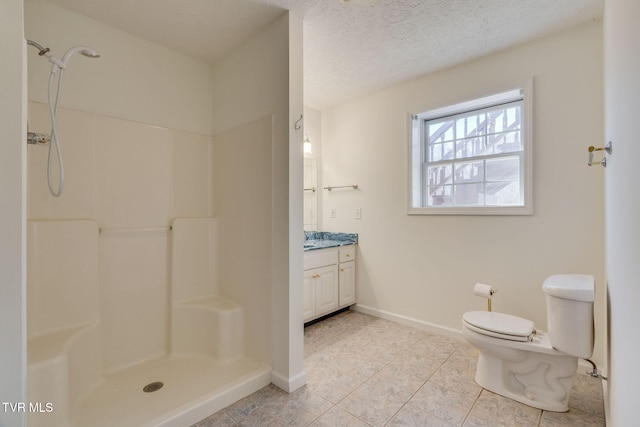 bathroom featuring toilet, a textured ceiling, vanity, and a shower