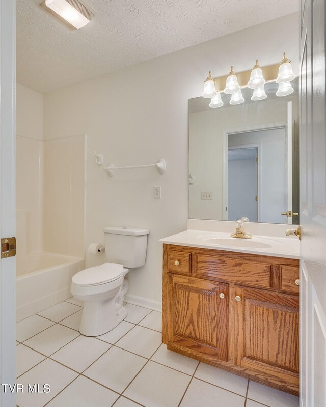 bathroom featuring vanity, tub / shower combination, tile patterned flooring, a textured ceiling, and toilet