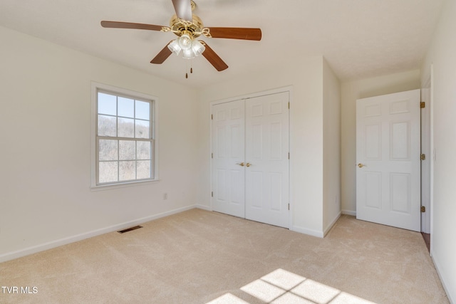 unfurnished bedroom featuring visible vents, ceiling fan, baseboards, carpet, and a closet