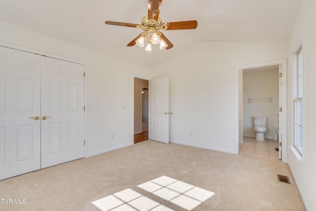 unfurnished bedroom with vaulted ceiling, carpet flooring, visible vents, and a closet