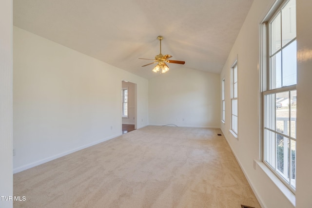 unfurnished room with visible vents, baseboards, light colored carpet, ceiling fan, and vaulted ceiling