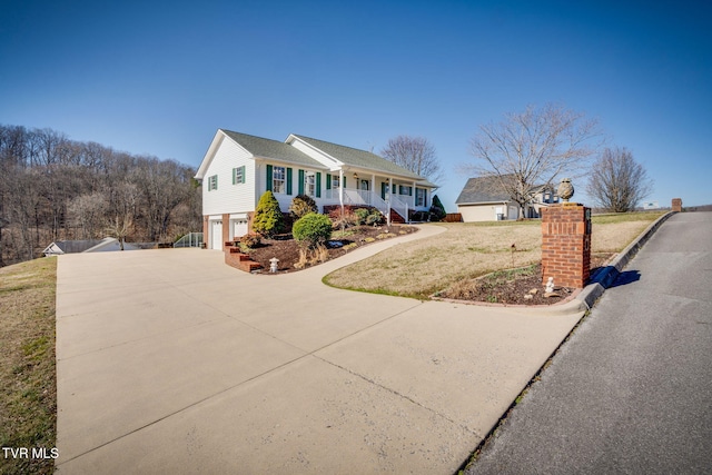 view of front of house featuring concrete driveway, covered porch, a garage, and a front yard