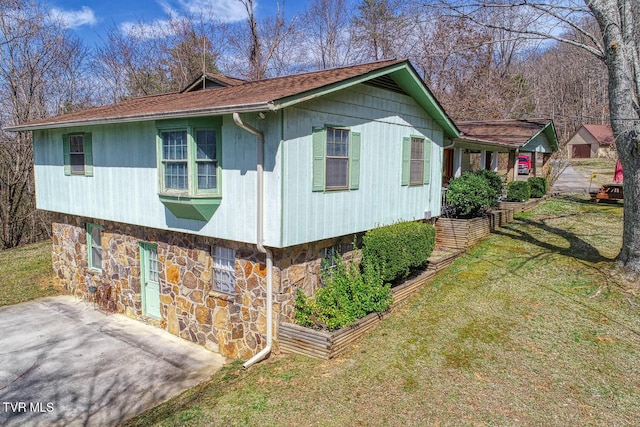 view of property exterior featuring a yard and stone siding