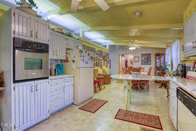 kitchen featuring brick wall, lofted ceiling with beams, light countertops, white appliances, and a ceiling fan