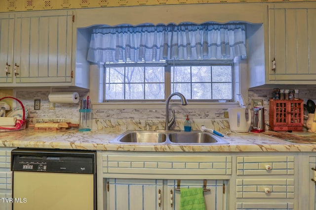 kitchen with dishwasher, light countertops, tasteful backsplash, and a sink