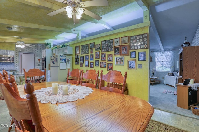 dining room featuring beam ceiling, a ceiling fan, brick wall, and carpet floors