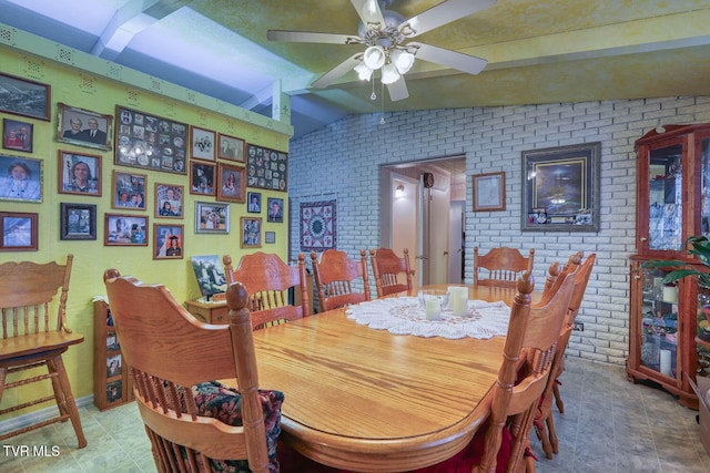 dining area with brick wall, a ceiling fan, and vaulted ceiling