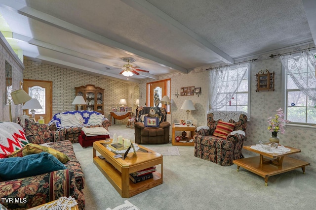 living area with wallpapered walls, ceiling fan, carpet, beamed ceiling, and a textured ceiling