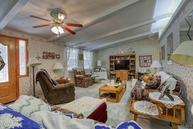 carpeted living room featuring vaulted ceiling with beams, a textured ceiling, wallpapered walls, and a ceiling fan