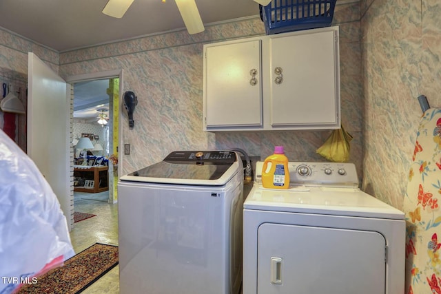 clothes washing area featuring ceiling fan, cabinet space, washing machine and dryer, and wallpapered walls