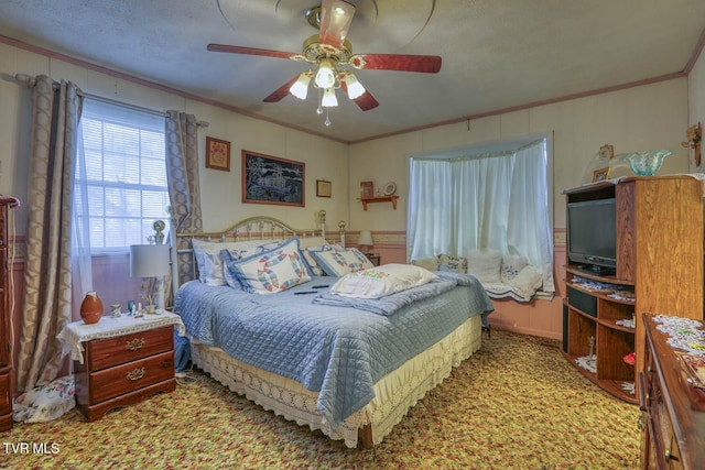 carpeted bedroom with a ceiling fan and ornamental molding