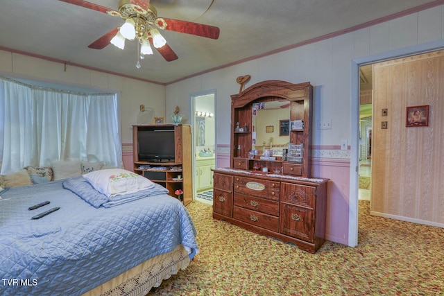 bedroom featuring light carpet, ensuite bath, ornamental molding, and a ceiling fan