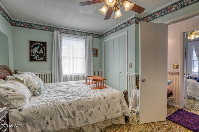 bedroom with a closet, a textured ceiling, ceiling fan, and ornamental molding