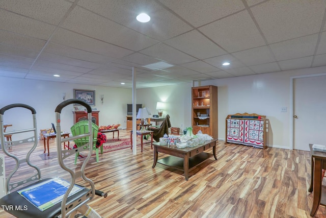 living area with recessed lighting, a paneled ceiling, and wood finished floors