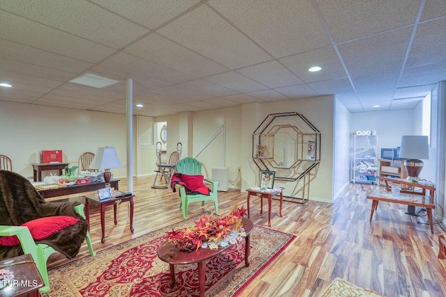 sitting room with recessed lighting, a paneled ceiling, baseboards, and wood finished floors