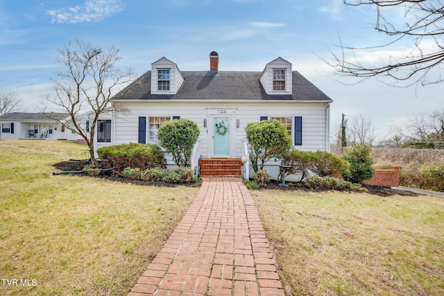 cape cod house featuring a front lawn, roof with shingles, and a chimney