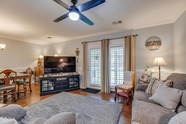 living area featuring a ceiling fan, crown molding, wood finished floors, and visible vents