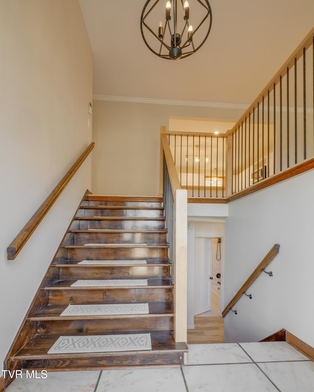 staircase with an inviting chandelier, crown molding, and a high ceiling