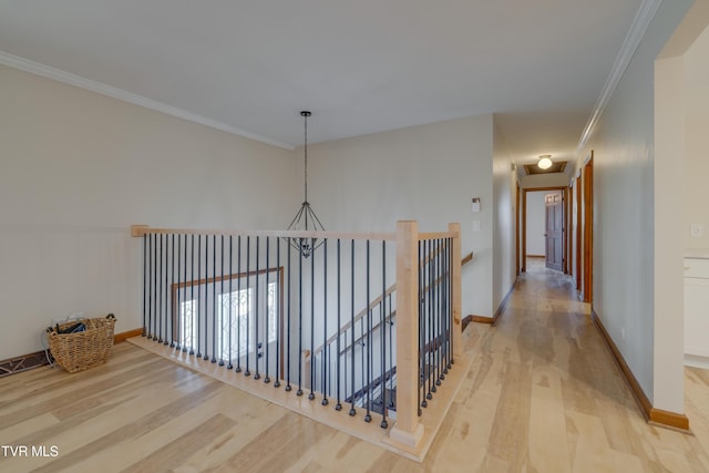 hall featuring baseboards, an upstairs landing, light wood-style floors, and crown molding