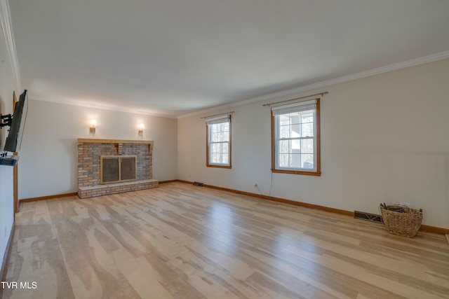 unfurnished living room with visible vents, a brick fireplace, wood finished floors, and ornamental molding