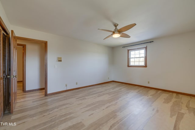 spare room with light wood-style flooring, baseboards, and ceiling fan