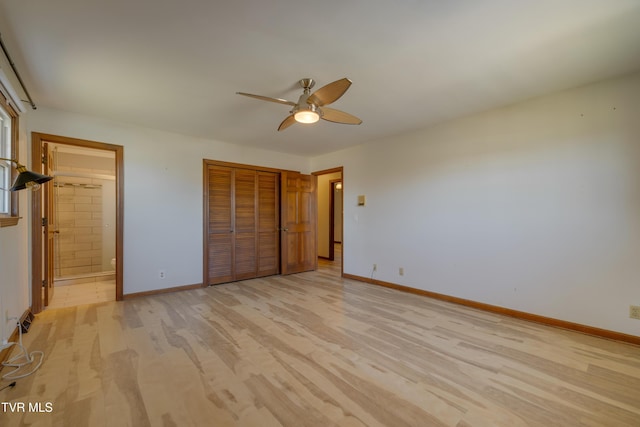 unfurnished bedroom featuring light wood-style flooring, baseboards, and a closet