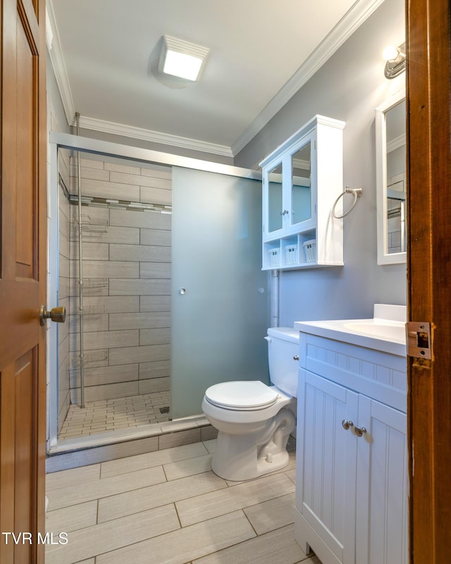 full bathroom with wood finish floors, toilet, a stall shower, ornamental molding, and vanity