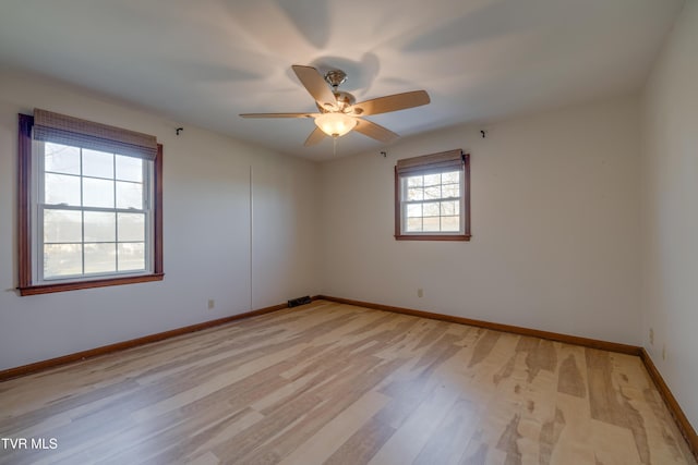 unfurnished room with visible vents, light wood-style floors, baseboards, and ceiling fan