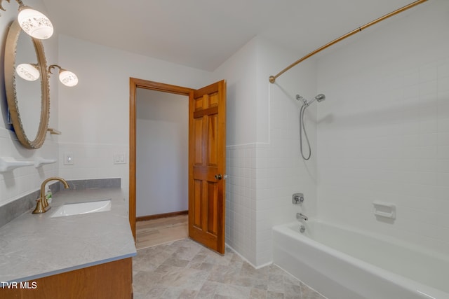 full bath with vanity, tile walls, tub / shower combination, and wainscoting