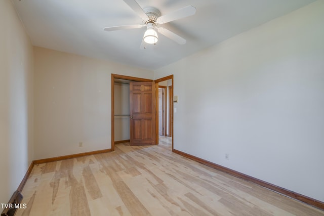 unfurnished bedroom featuring a closet, light wood-style flooring, a ceiling fan, and baseboards