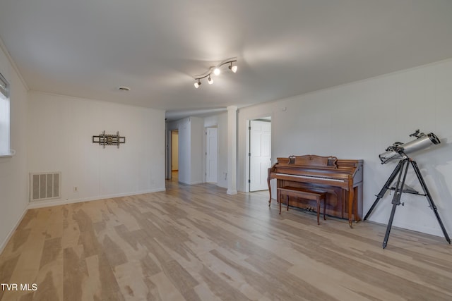 interior space with baseboards, visible vents, and light wood finished floors