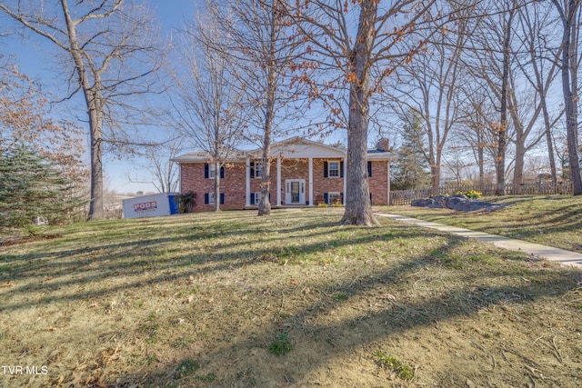 neoclassical / greek revival house featuring a front lawn, fence, and brick siding