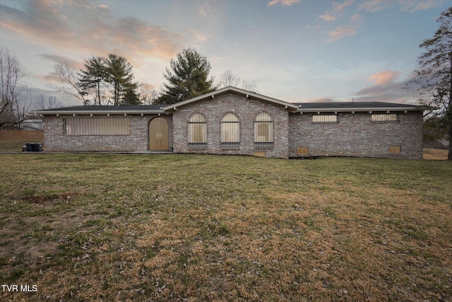 view of front facade with a lawn and brick siding