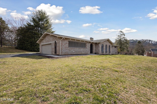 single story home featuring a front lawn, an attached garage, brick siding, and aphalt driveway