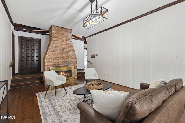 living room with ornamental molding, a brick fireplace, and wood finished floors