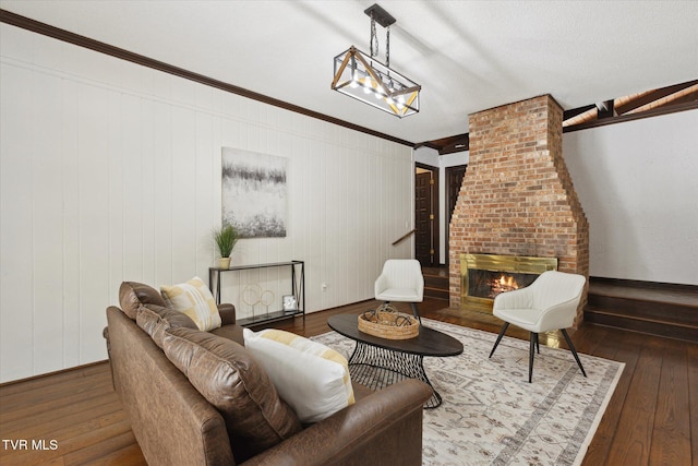 living area with hardwood / wood-style flooring, a brick fireplace, and ornamental molding