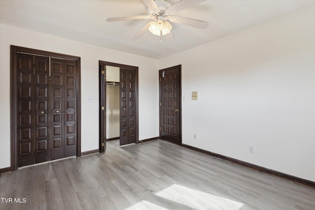 unfurnished bedroom featuring wood finished floors, baseboards, a closet, and ceiling fan