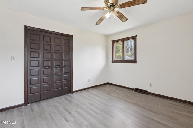 unfurnished bedroom featuring visible vents, baseboards, ceiling fan, light wood-style flooring, and a closet