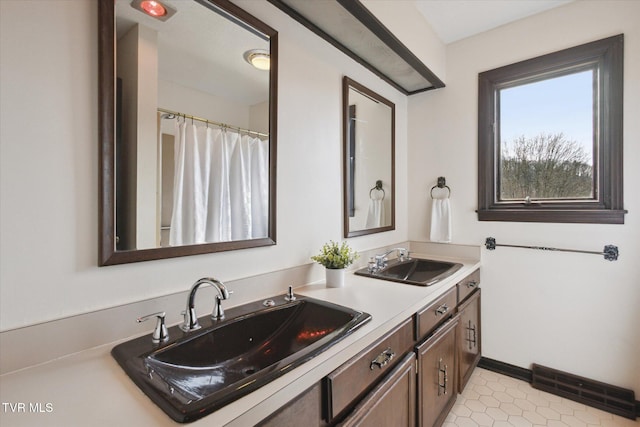 bathroom featuring double vanity, visible vents, tile patterned floors, and a sink