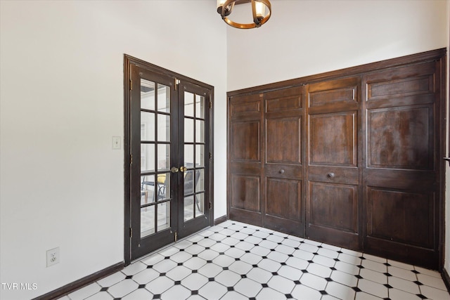 entryway featuring a high ceiling, french doors, baseboards, and light floors