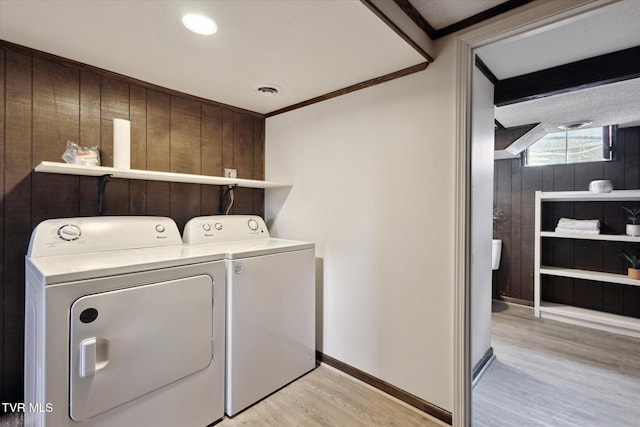 washroom featuring washer and dryer, laundry area, light wood-style flooring, and ornamental molding