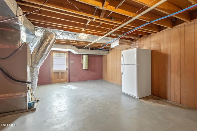 below grade area with wood walls and freestanding refrigerator